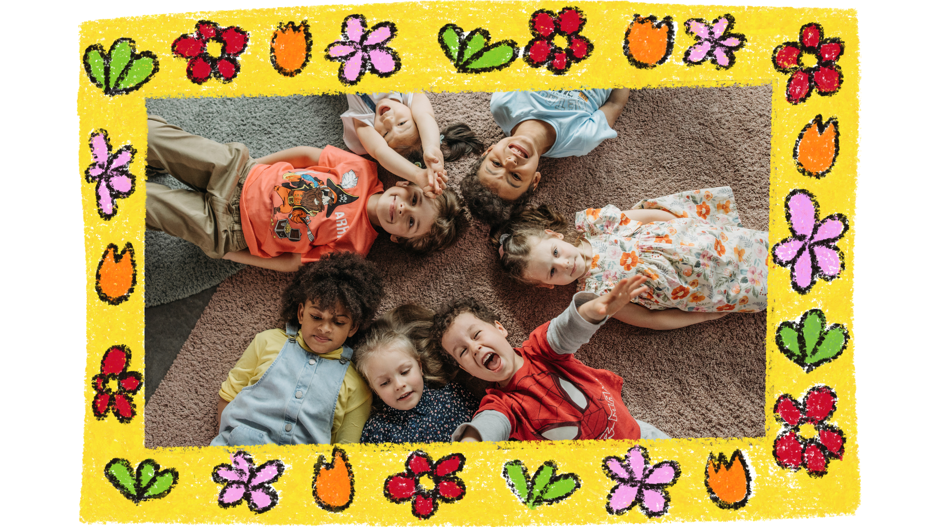 Group of children lying in a circle on a carpeted floor, smiling and laughing while looking up at the camera. The photo is framed with a colorful, crayon-like border featuring flowers, hearts, and tulips in vibrant colors like red, orange, pink, green, and yellow. The playful and cheerful design complements the joyful expressions of the children, creating a warm and lively atmosphere.